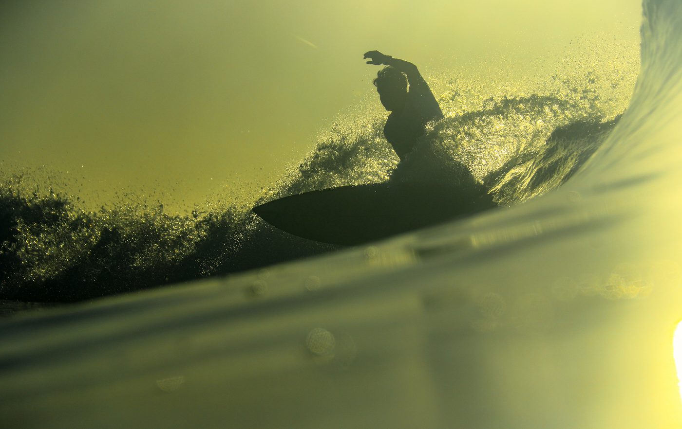 Surfer confidently riding a green wave during an intermediate coaching session